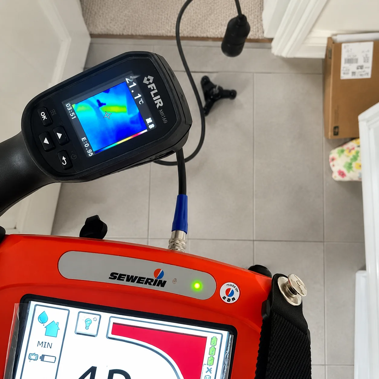 Plumber using a thermal camera and acoustic leak detector to find a hidden leak in Barrie